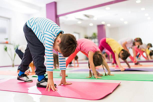 rec classes photo Large group of children doing stretching exercises in a health club. Focus is on boy in striped t-shirt.